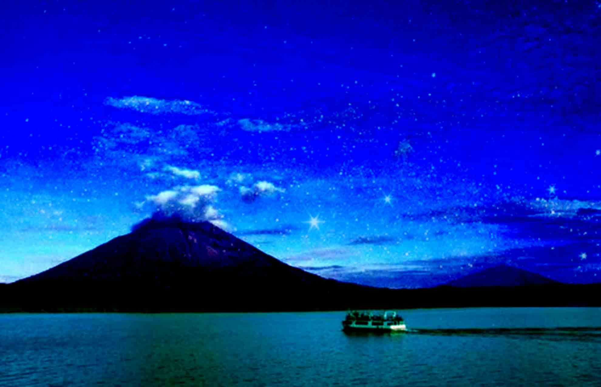 A volcanic cone sitting in a lake, evening sky, and a ferry boat