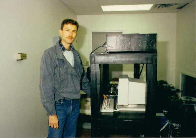 Steve standing next to a wooden laser projector stand