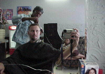 Me getting a haircut in Bulawayo Zimbabwe. Local people amazed by my digital camera with a "TV in it"